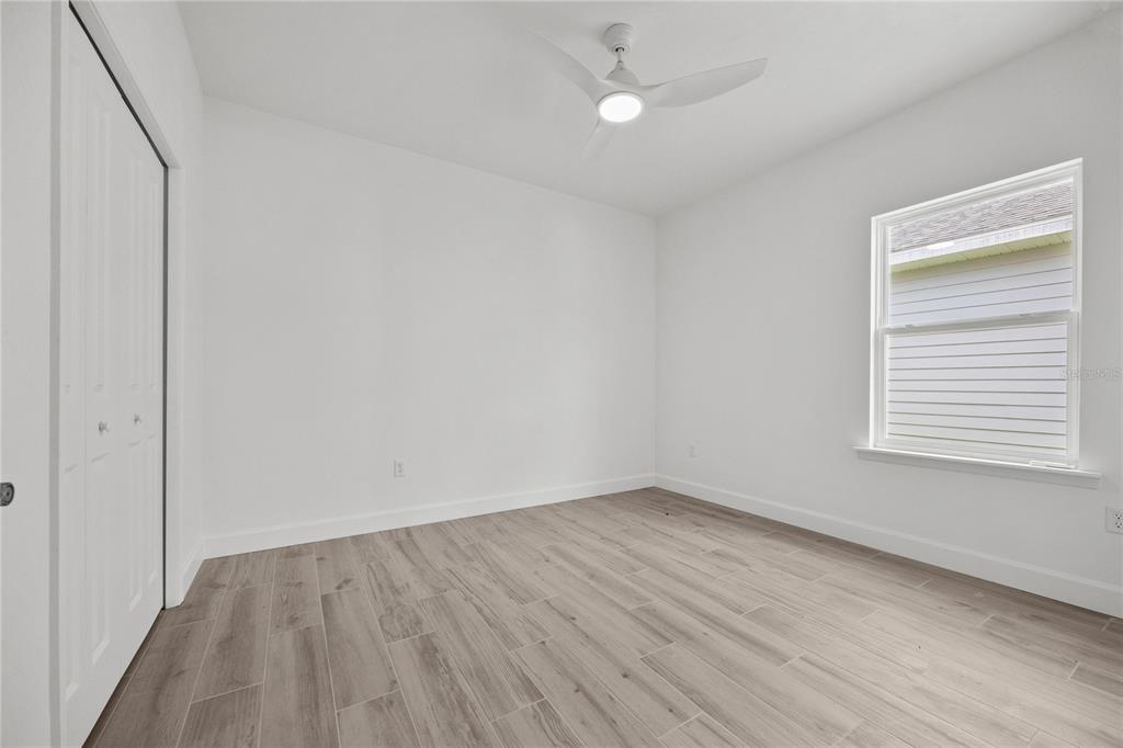 1018 Southwest 67th Drive Gainesville, FL 32607 - Photo 20 of 29 a view of an empty room with wooden floor and a window