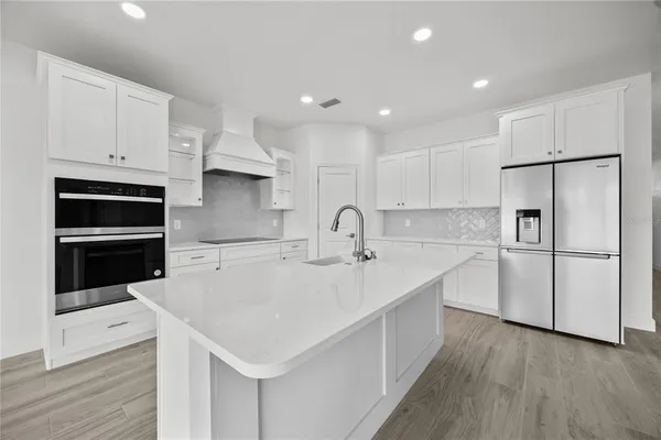a kitchen with white cabinets appliances and sink