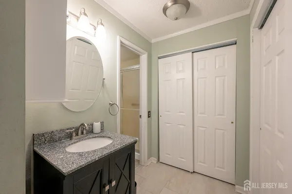 a bathroom with a granite countertop sink and a mirror