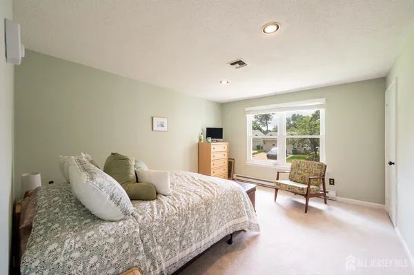 a bedroom with a bed and large windows