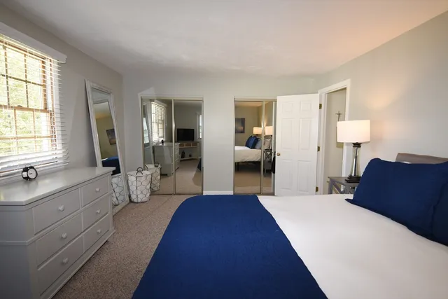 a large bedroom with a large bed and windows