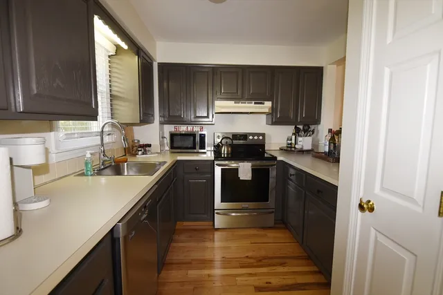 a kitchen with a sink a stove top oven and cabinetry
