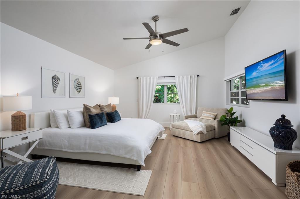 339 4th Avenue North Naples, FL 34102 - Photo 15 of 48 a bedroom with a bed couches and a flat tv screen