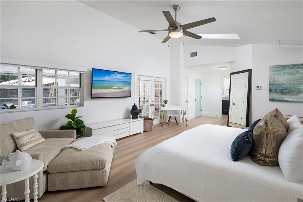 339 4th Avenue North Naples, FL 34102 - Photo 16 of 48 a bedroom with a bed a couch and a chandelier