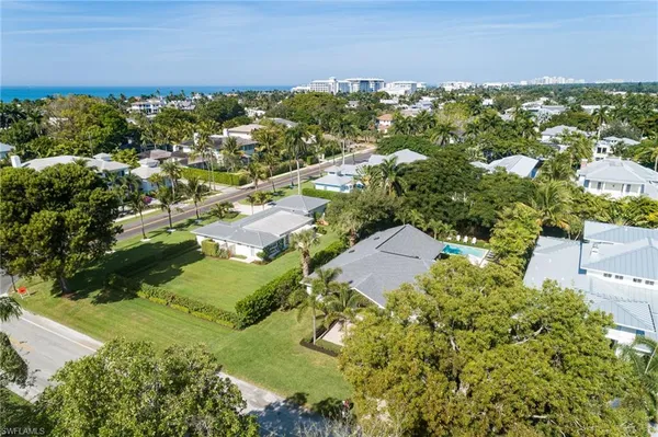 an aerial view of residential houses with outdoor space and trees