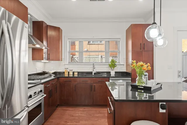 a large kitchen with a table chairs refrigerator and cabinets