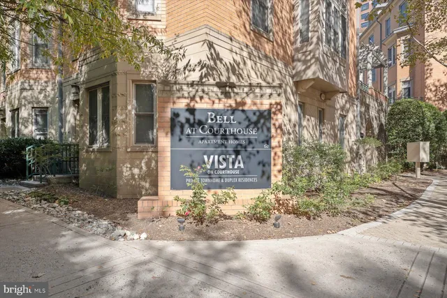 a sign board with building in the background