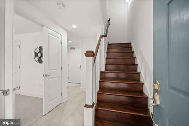 a kitchen with stainless steel appliances a refrigerator a sink a dining table and chairs