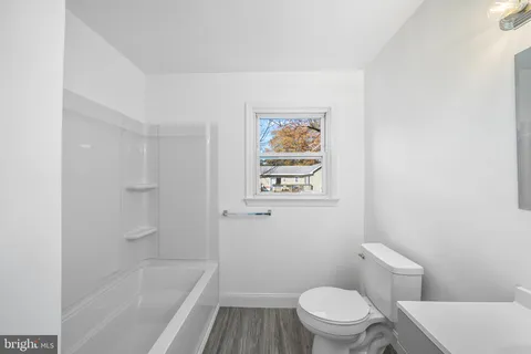 a white toilet sitting next to a bath tub
