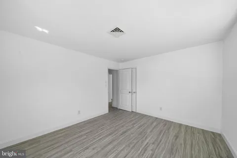 a view of a room with wooden floor and white walls