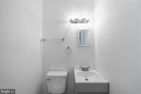 a bathroom with a sink a toilet and mirror