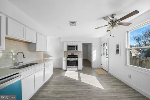 a kitchen with granite countertop a stove a sink and a refrigerator