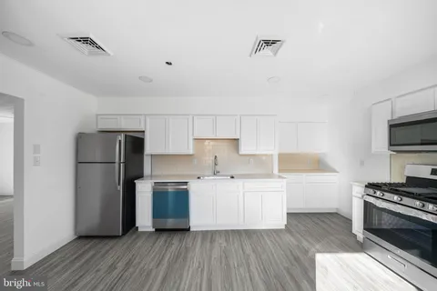 a kitchen with a refrigerator and a stove top oven