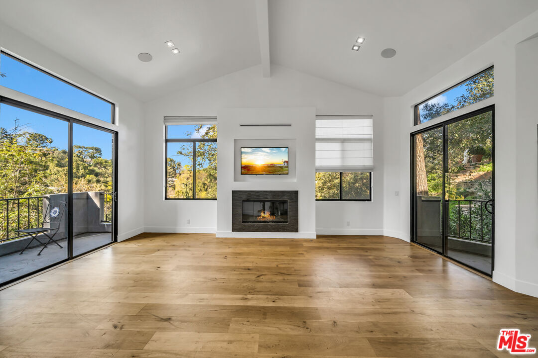 a view of an empty room with window and fire place
