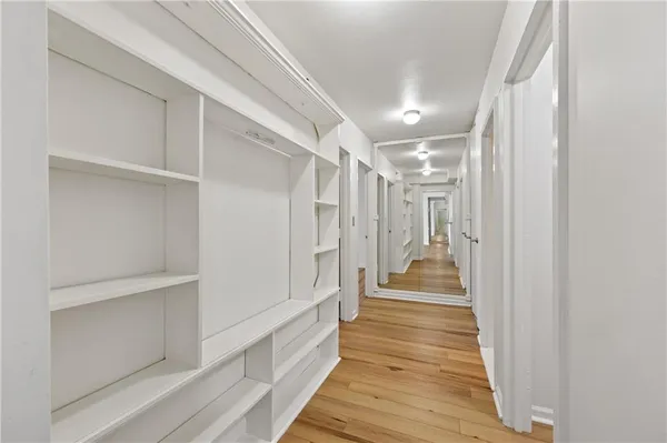 a view of a hallway with wooden floor and staircase