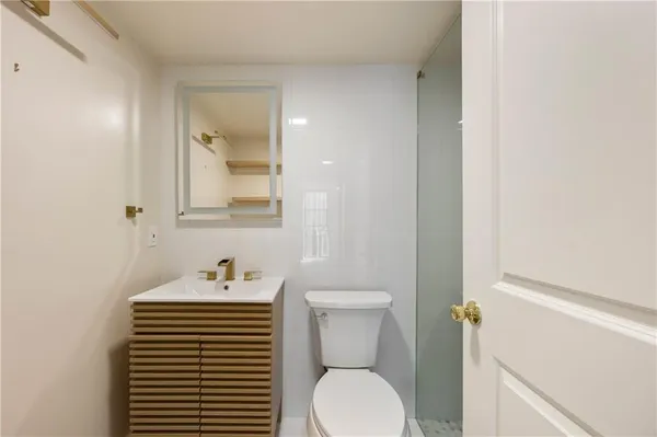 a bathroom with a toilet sink and mirror