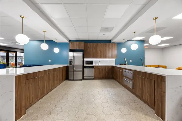 a kitchen with stainless steel appliances a sink a counter top space cabinets and a chandelier