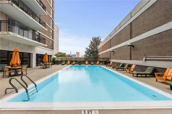 a view of swimming pool with outdoor seating and car parked