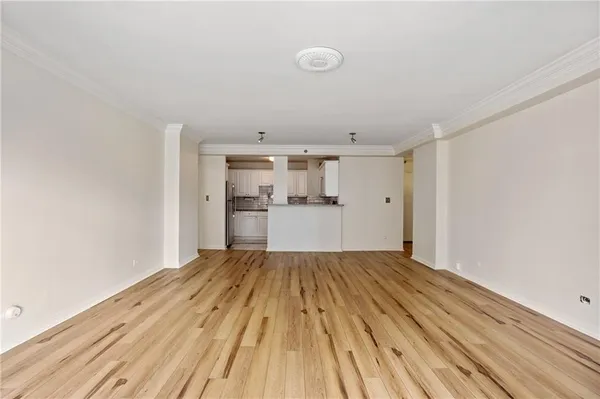 a view of empty room with wooden floor