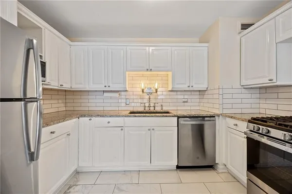 a kitchen with white cabinets stainless steel appliances and sink