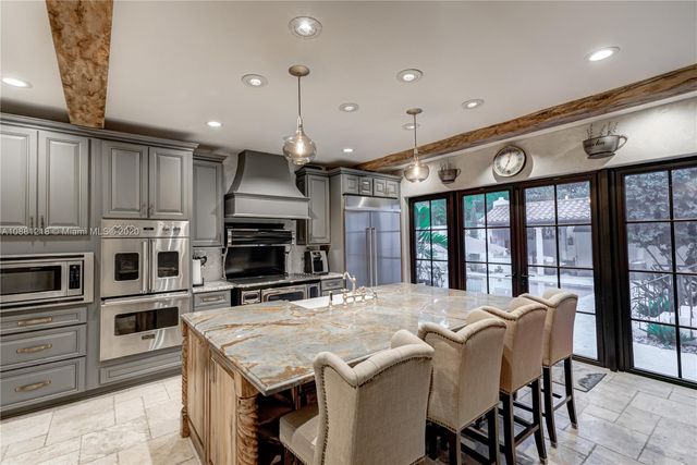 a kitchen with stainless steel appliances granite countertop a stove top oven a sink and a refrigerator