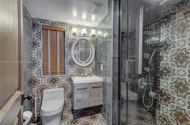 a bathroom with a toilet a sink and mirror