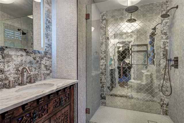 a bathroom with a granite countertop shower a sink and a mirror