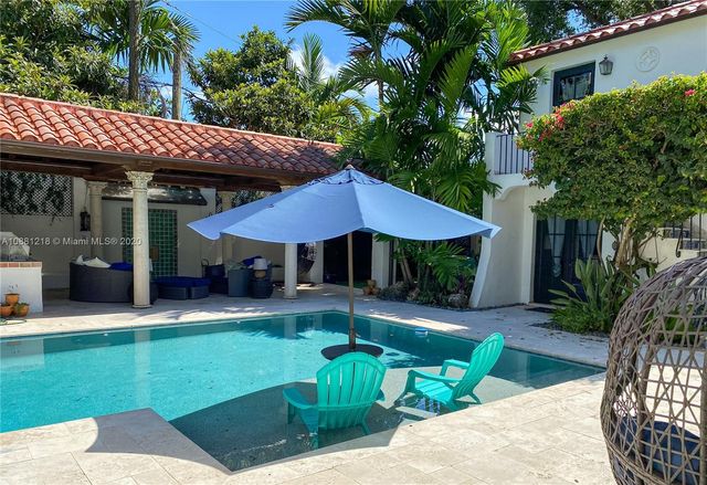 a front view of a house with a yard table and chairs