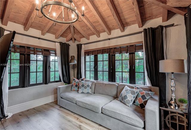 a living room with furniture fireplace and a large window