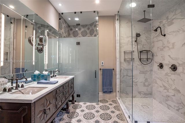 a bathroom with a double vanity sink mirror and shower