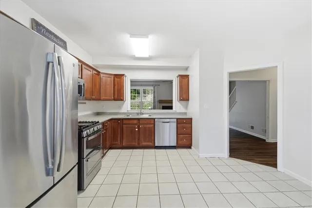 a kitchen with stainless steel appliances granite countertop a refrigerator and a sink
