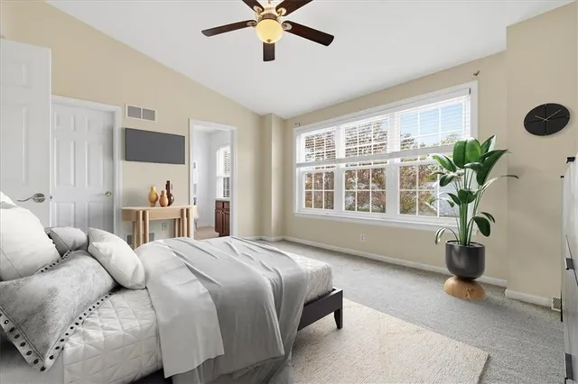 a bedroom with a large bed and potted plant