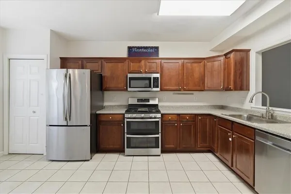 a kitchen with granite countertop a refrigerator and a sink