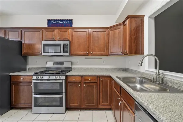 a kitchen with stainless steel appliances granite countertop a sink stove and microwave