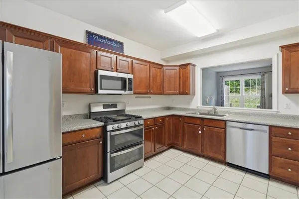 a kitchen with granite countertop cabinets stainless steel appliances and a window