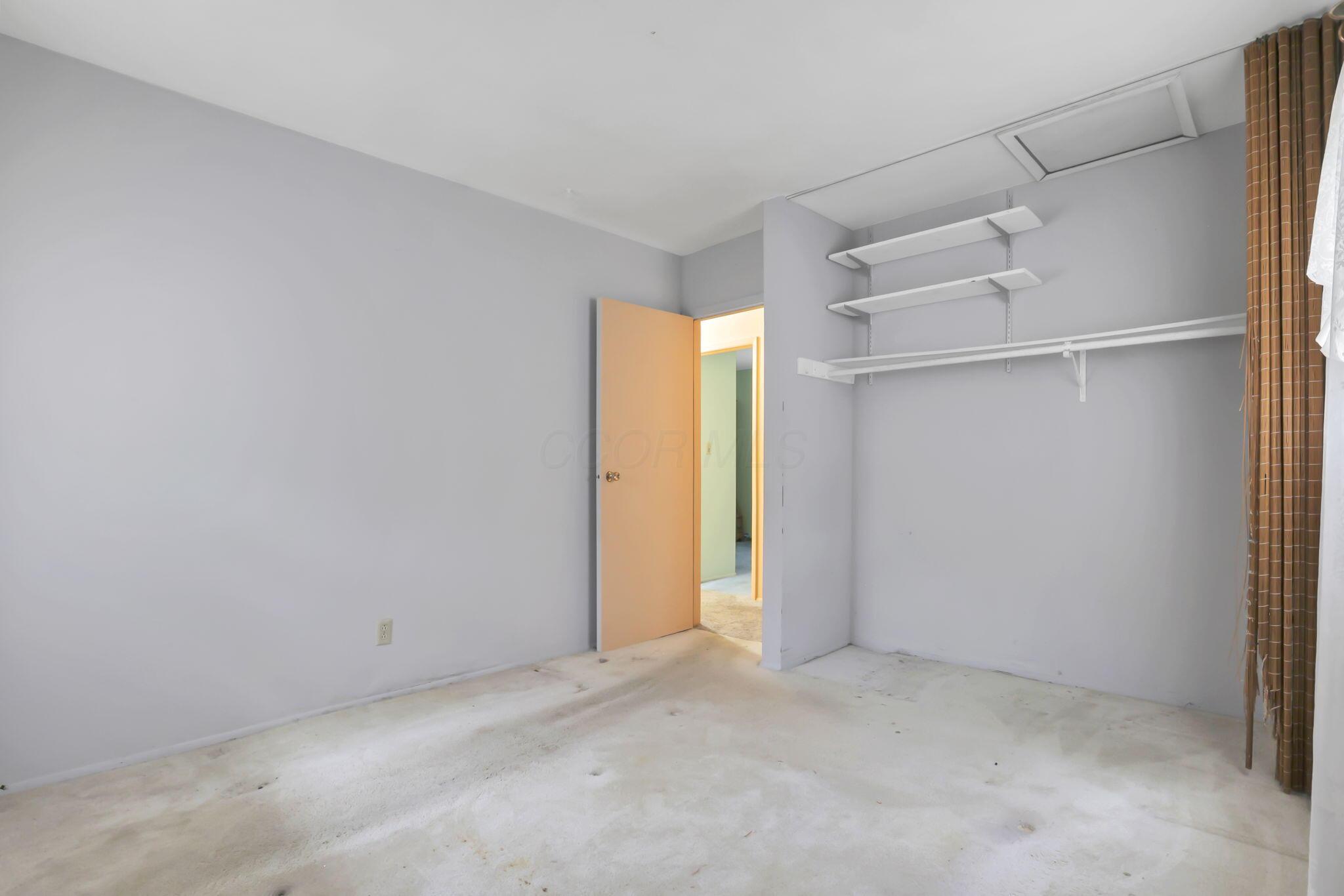 3882 Glenfield Road Columbus, OH 43232 - Photo 23 of 29 Spacious room featuring light gray walls, an open doorway, and a built-in closet area with shelving and a hanging rod