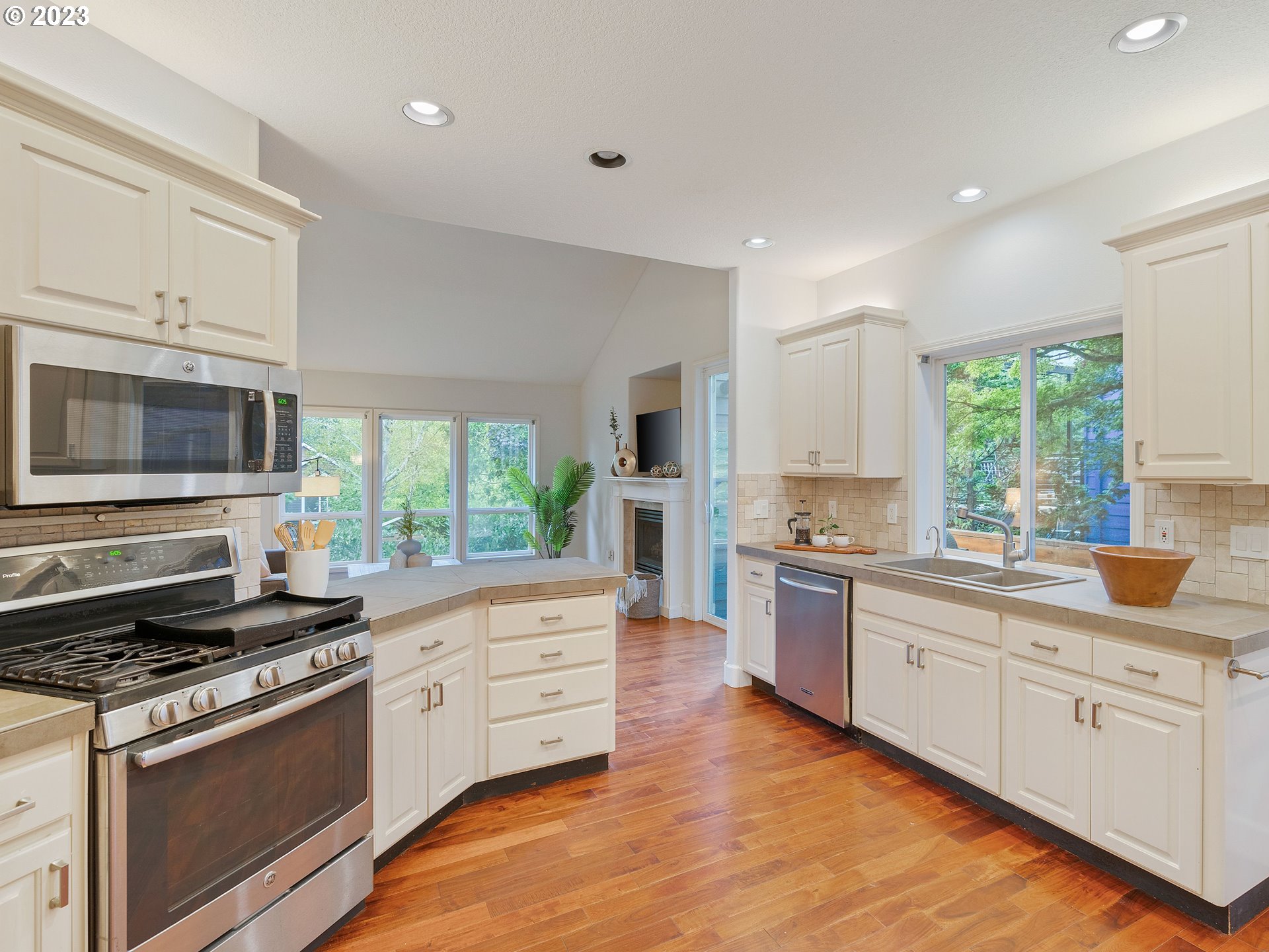 11320 Northwest Kearney Street Portland, OR 97229 - Photo 11 of 16 a kitchen with stainless steel appliances white cabinets a sink and a stove