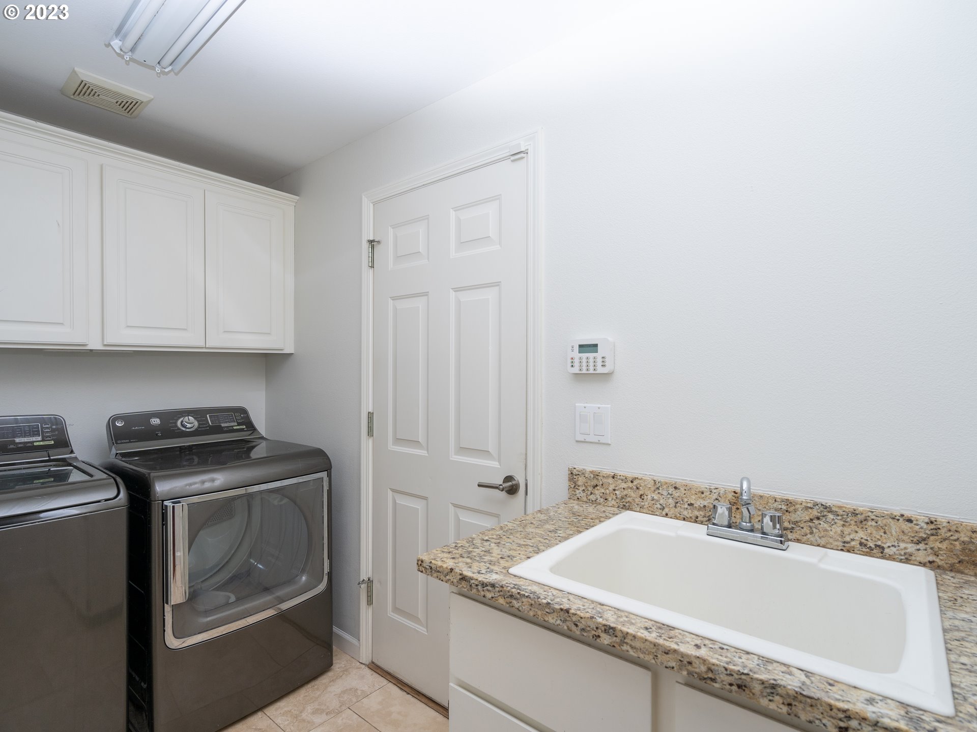 11320 Northwest Kearney Street Portland, OR 97229 - Photo 5 of 16 a bathroom with a granite countertop sink and washing machine