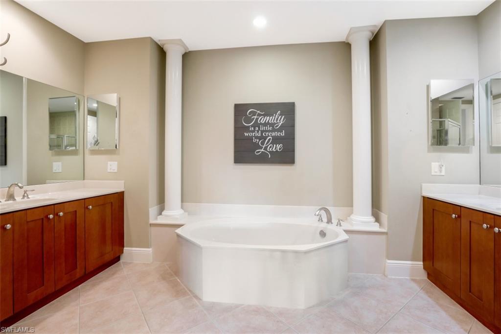 9224 Campanile Circle, Unit 101 Naples, FL 34114 - Photo 20 of 32 a spacious bathroom with a bathtub and a double vanity sink