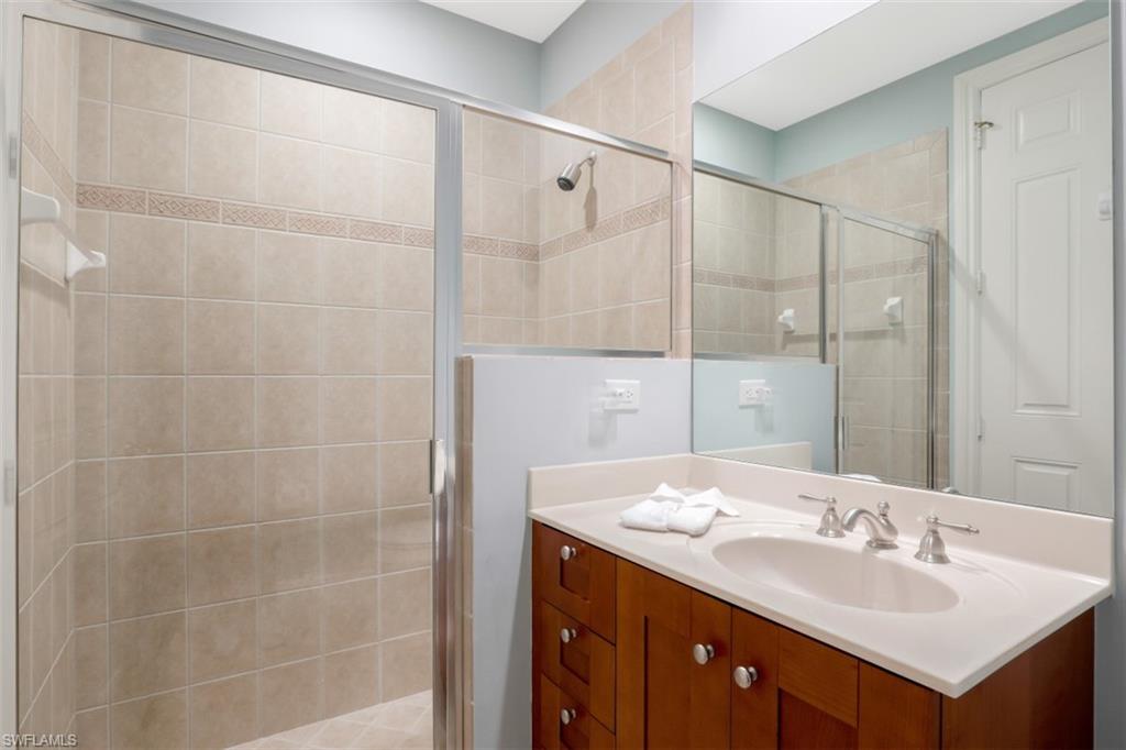 9224 Campanile Circle, Unit 101 Naples, FL 34114 - Photo 22 of 32 a bathroom with a double vanity sink mirror and shower