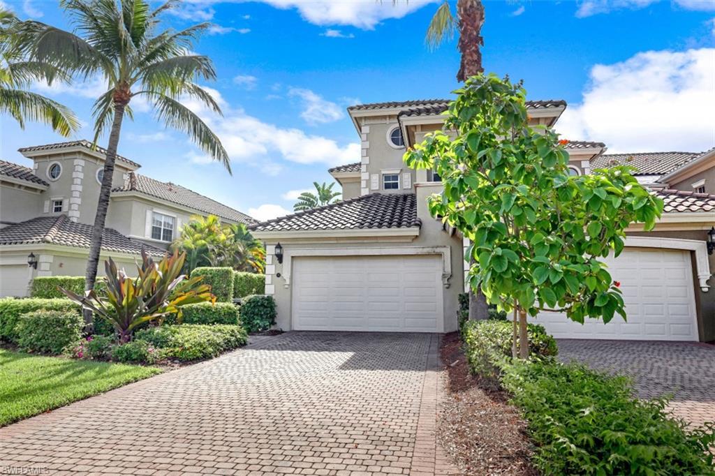 9224 Campanile Circle, Unit 101 Naples, FL 34114 - Photo 31 of 32 a front view of a house with a yard and potted plants