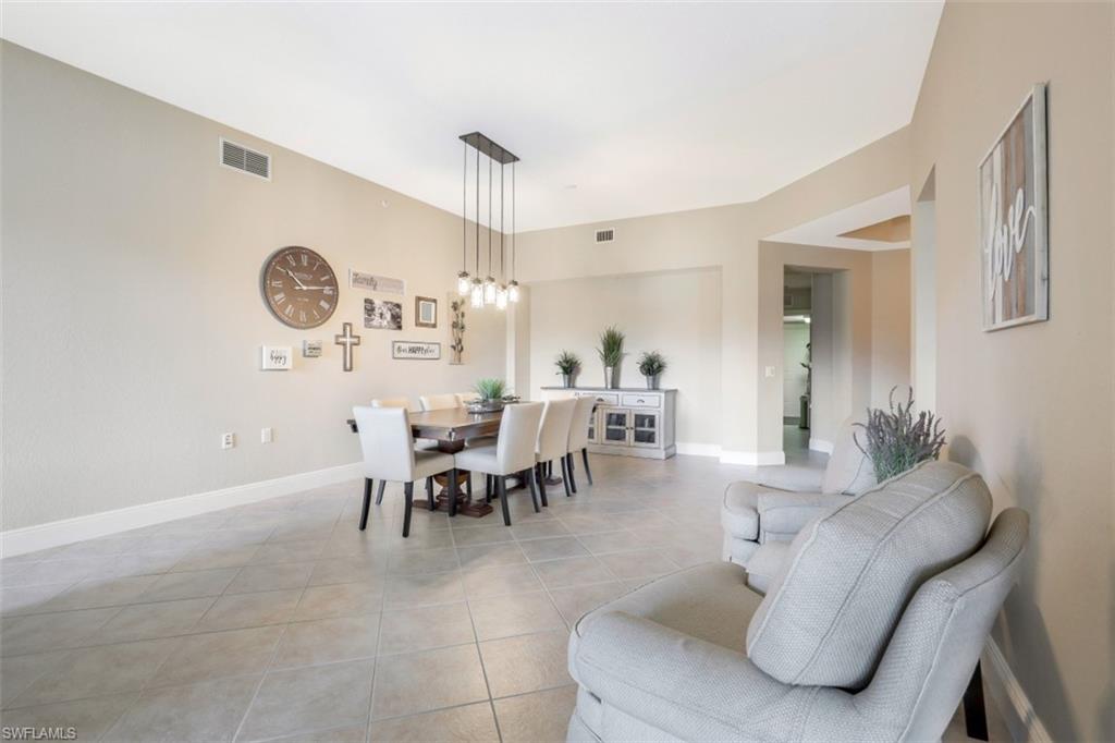 9224 Campanile Circle, Unit 101 Naples, FL 34114 - Photo 5 of 32 a dining room with furniture and a clock