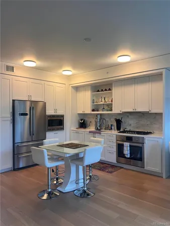 a kitchen with a refrigerator and a stove top oven