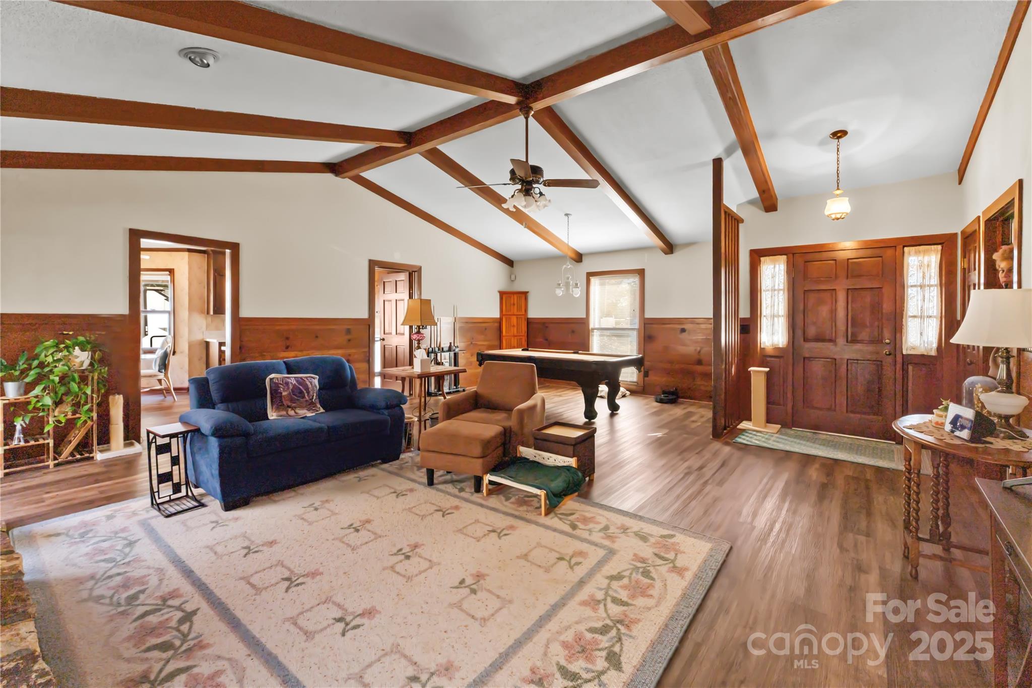 a living room with furniture and a wooden floor