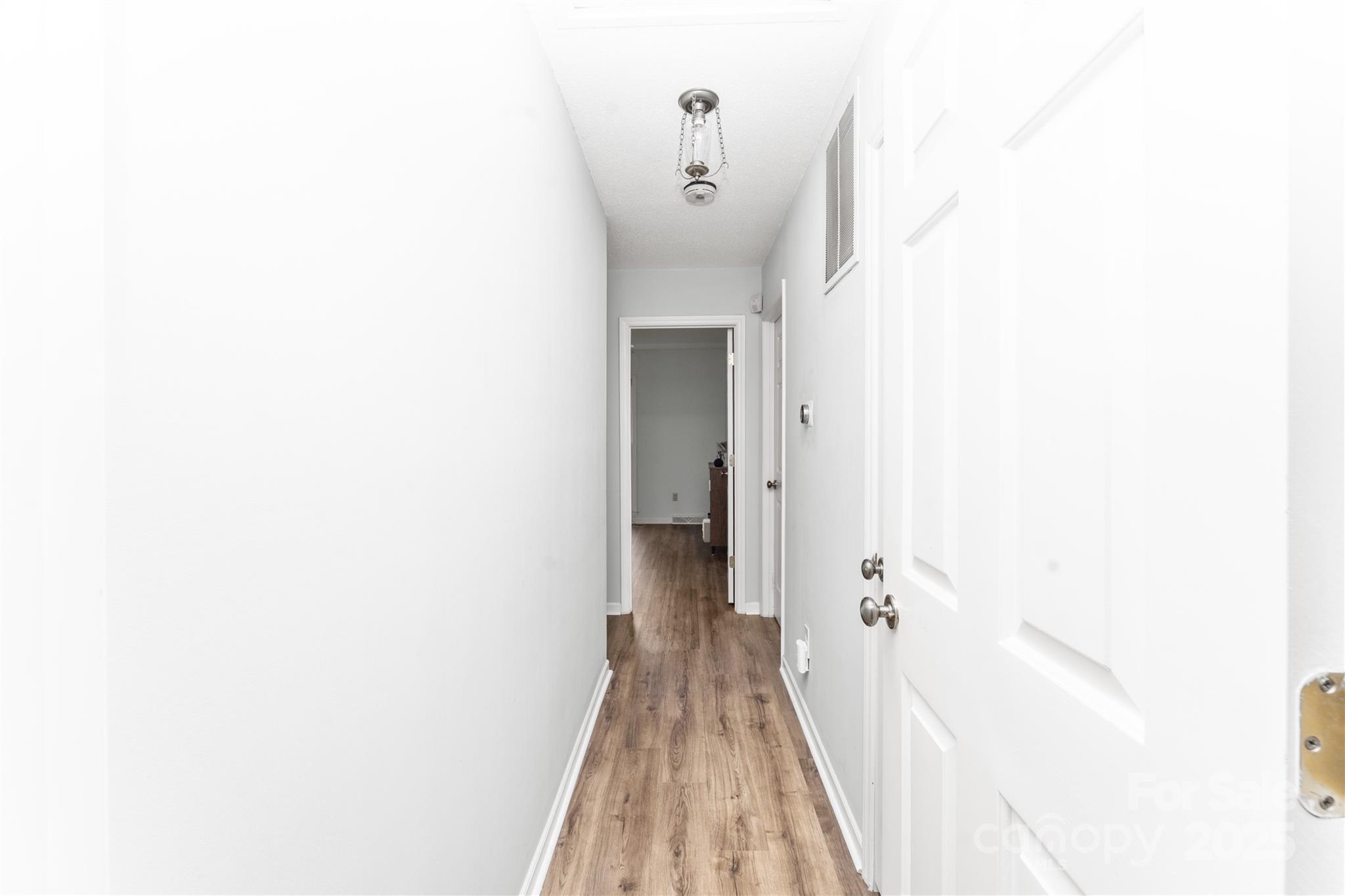 3614 McKee Road Charlotte, NC 28270 - Photo 17 of 29 a view of a hallway with wooden floor and a bathroom