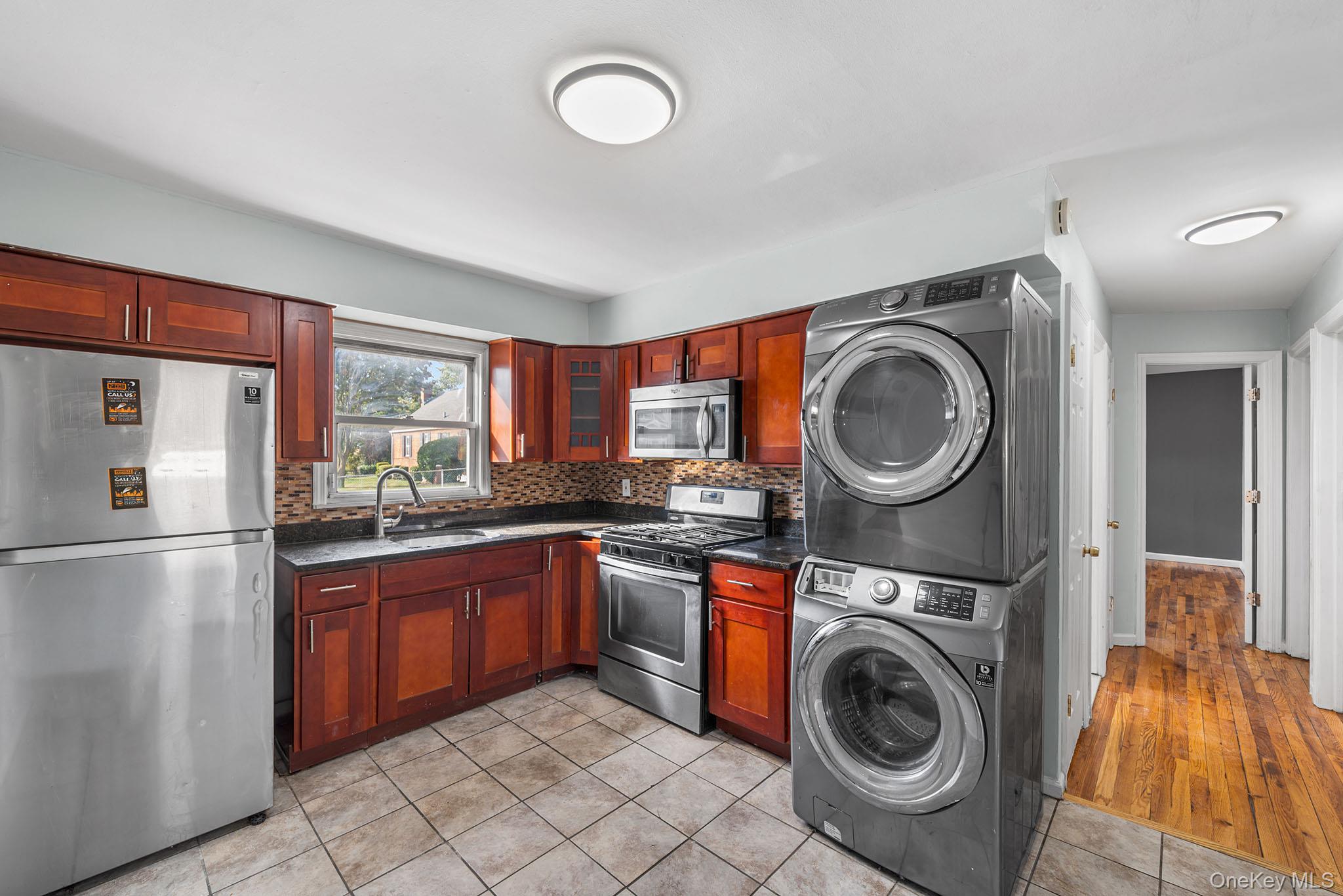 172-04 Amelia Road Queens, NY 11434 - Photo 11 of 25 a kitchen with stainless steel appliances granite countertop a sink a stove top oven and refrigerator