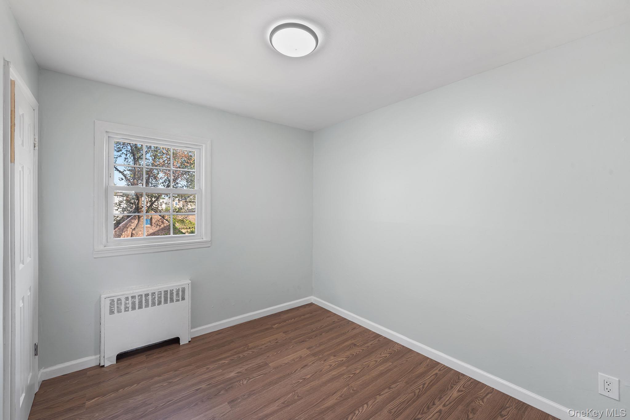 172-04 Amelia Road Queens, NY 11434 - Photo 20 of 25 a view of an empty room with wooden floor and a window