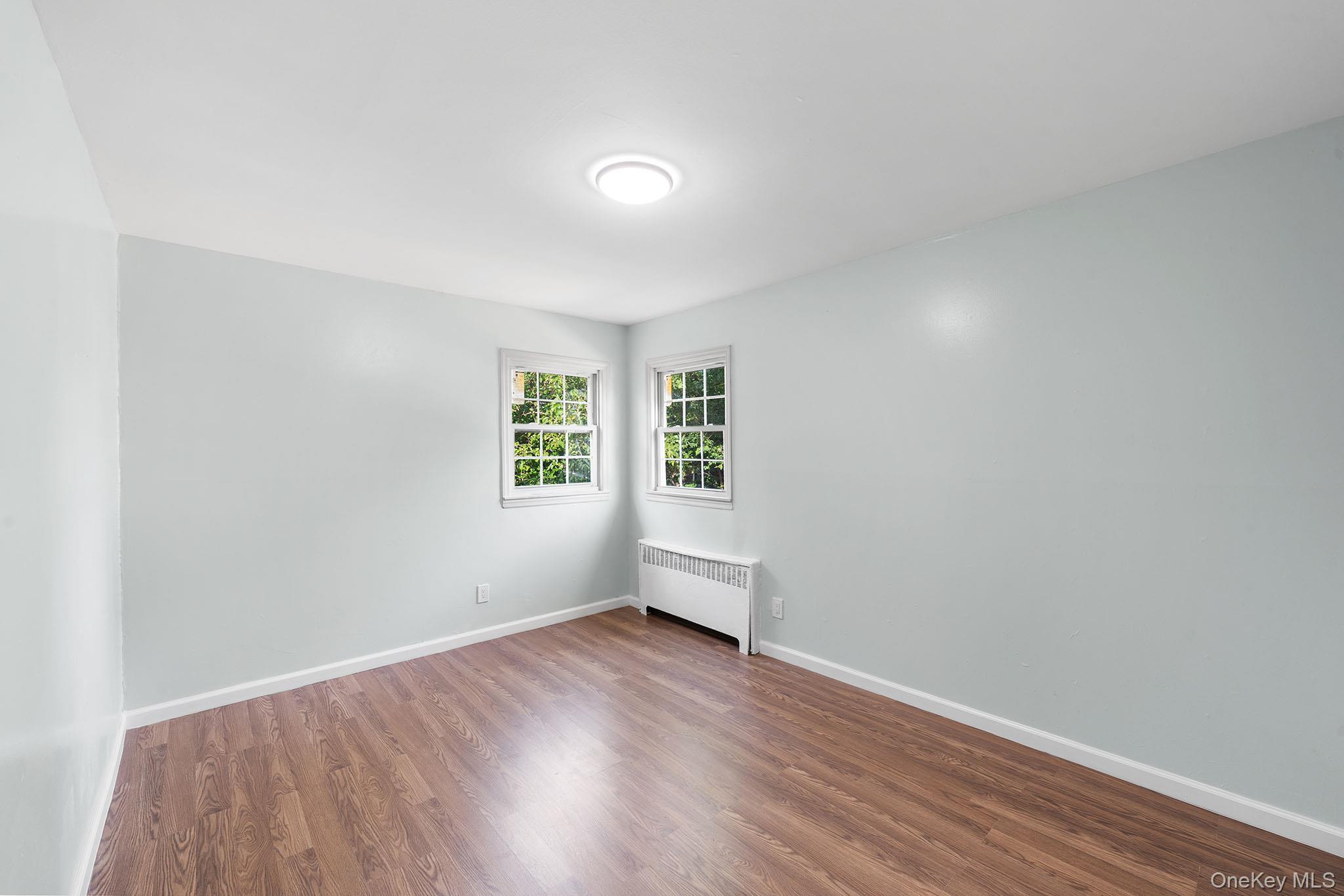 172-04 Amelia Road Queens, NY 11434 - Photo 22 of 25 an empty room with wooden floor and windows