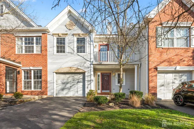a view of a white house with a yard and large tree