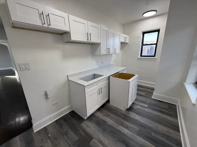 a utility room with wooden floor washer and dryer